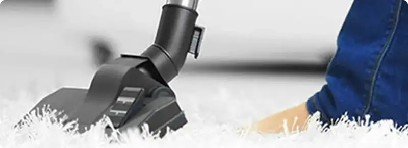 Close-up of a professional vacuuming a white carpet in Cottage Grove.